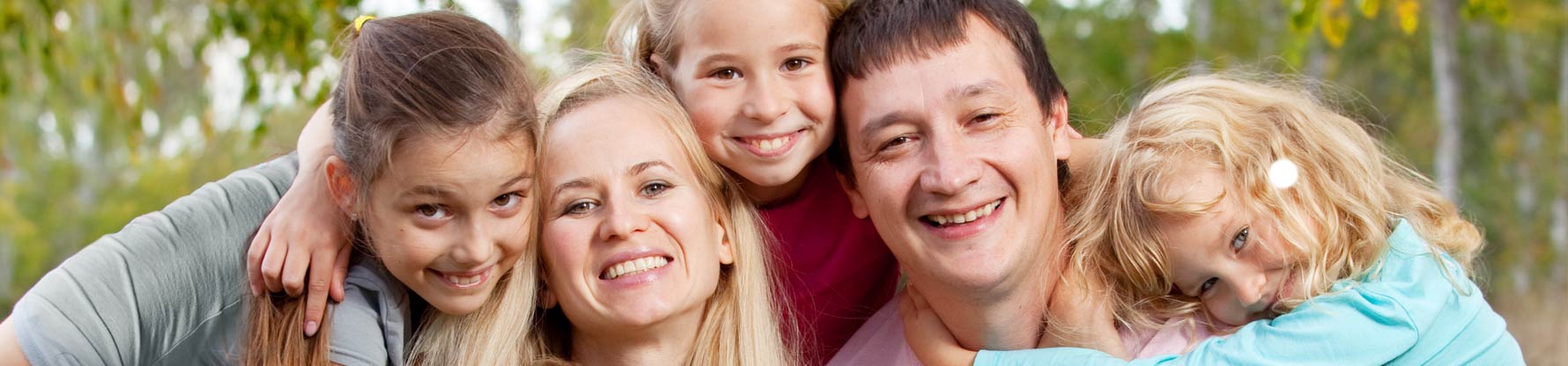 Eine Familie mit drei Mädchen umarmt sich